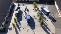 Foto: Luftaufnahme des Schulhofs in Vilich. Auf dem Schulhof stehen verschiedene Fahrzeuge des THW. Außerdem befinden sich Schülerinnen und Schüler sowie Mitarbeitende des Schule und des THW auf dem Hof.