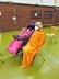 Foto: Rollstuhlkind mit pinkem Mantel und Erwachsene in eine orange Decke gewickelt. 