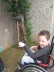 Das Foto zeigt einen Schüler im Rollstuhl, der mit einem hängenden Schlegel ein Röhrenklangspiel bewegt.