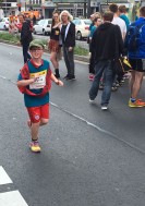Das Foto zeigt einen Läufer aus dem 4. Schuljahr mit der Schulschärpe auf der Strecke.