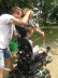 Das Foto zeigt einen Rollstuhlfahrer, auf dessen Rollstuhl der Bogen von zwei Erwachsenen abgestützt wird. 